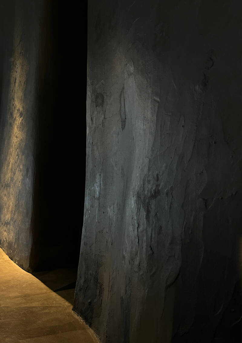 Parede texturada escura com luz rasante